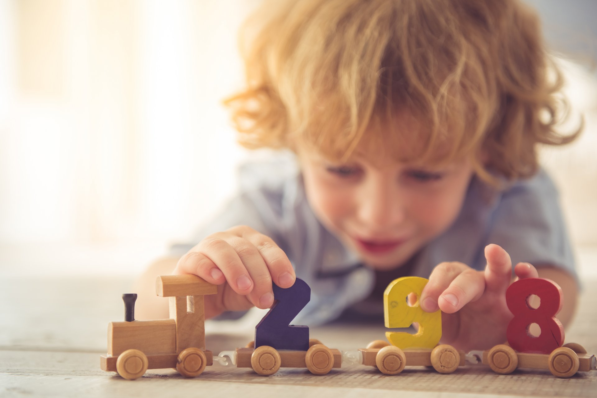 Kind spielt mit einem Spielzeug aus Holz.