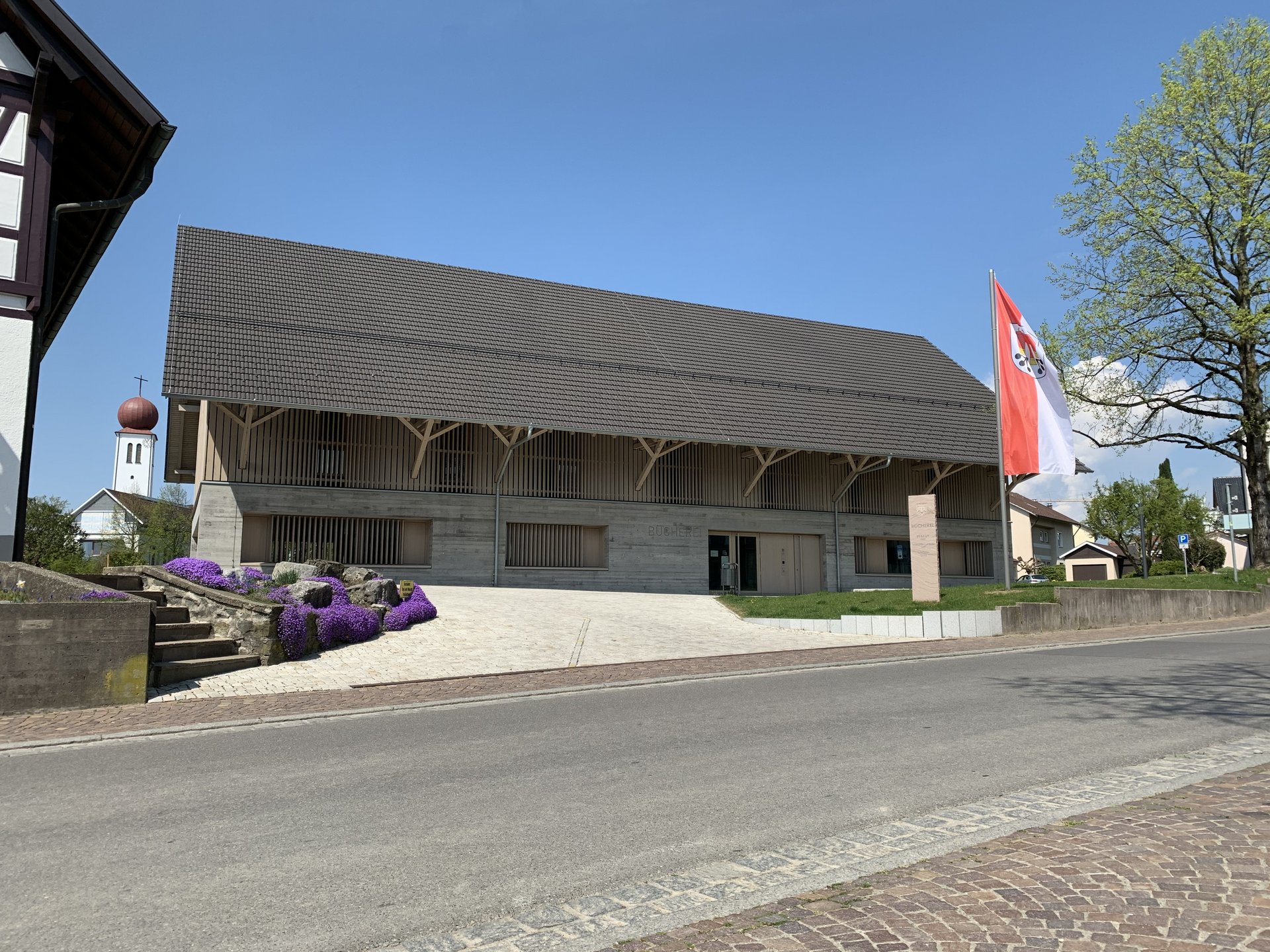 Gemeindebücherei Außenansicht mit Kirchturm im Hintergrund