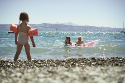 Kinder mit Schwimmflügel und Luftmatratze am Bodensee